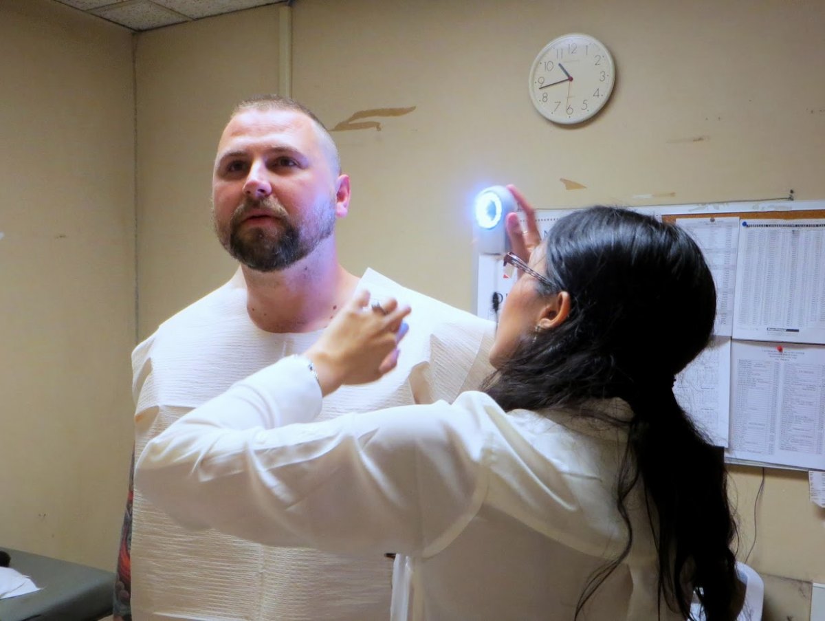 Rupa Pugashetti, MD, examines Thomas Busse's neck for possible signs of skin cancer.