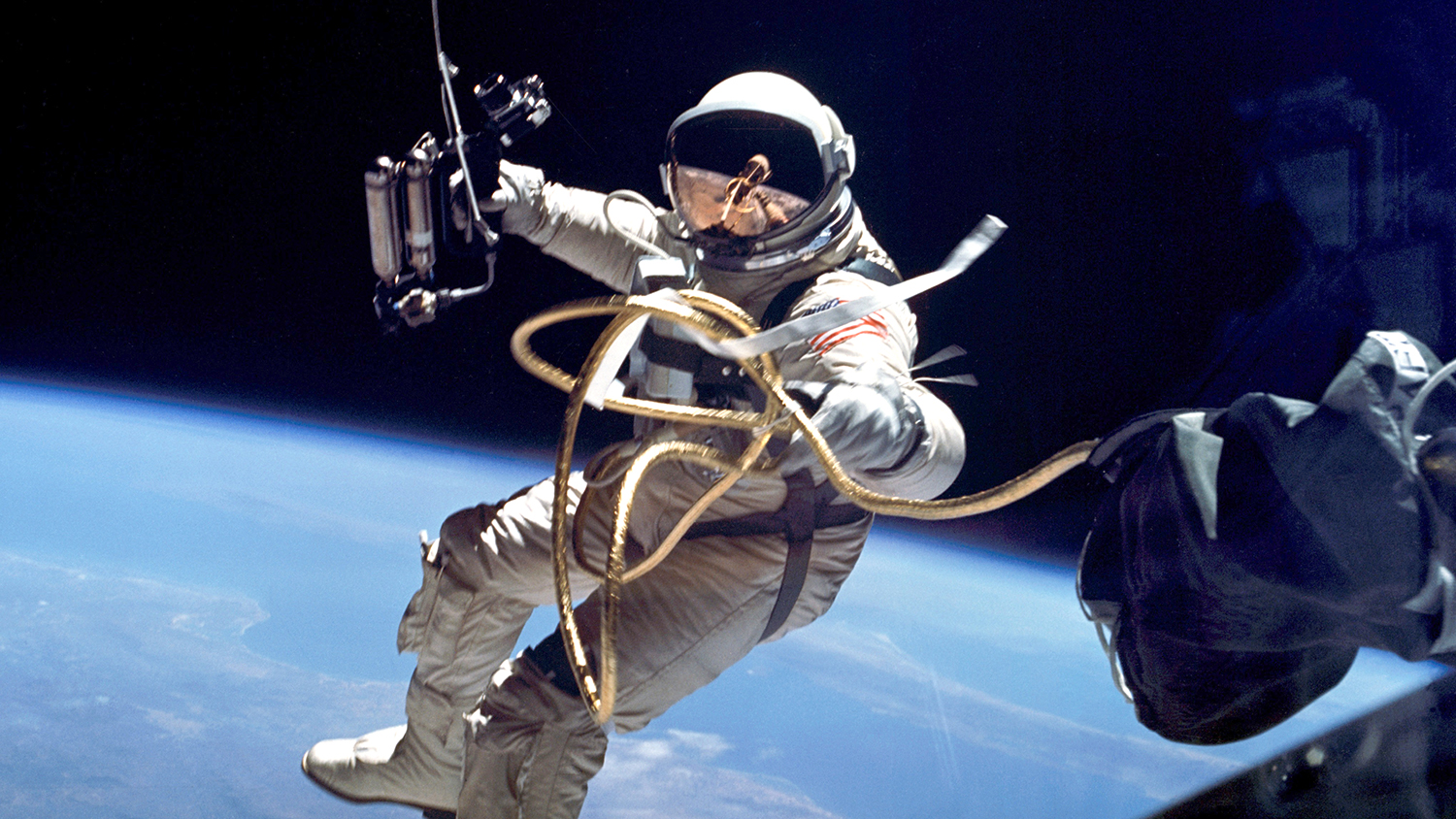 an astronaut on a spacewalk with Earth behind him