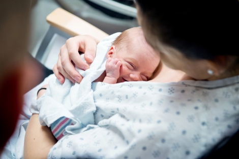 a woman holds a newborn in the hospital