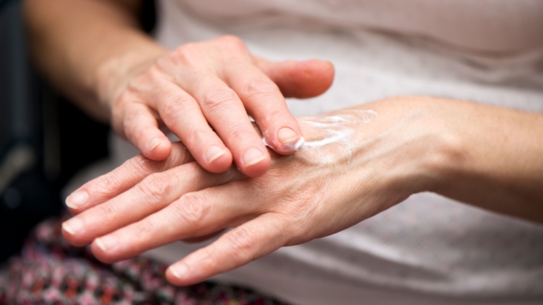 Hands rubbing lotion.
