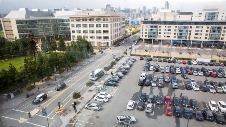 wide view of the Mission Bay campus, with the 4th street surface parking lot in the foreground