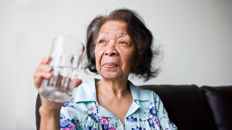 stock image of senior African American woman looking out the window
