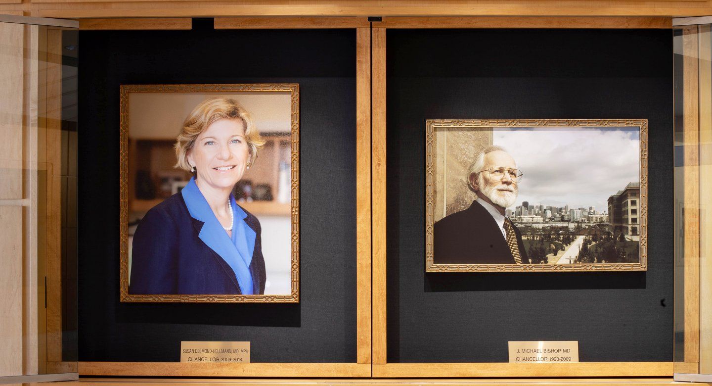 a portrait of Susan Desmond-Hellmann and Michael Bishop hang in the Medical Sciences Building on the Parnassus Heights campus