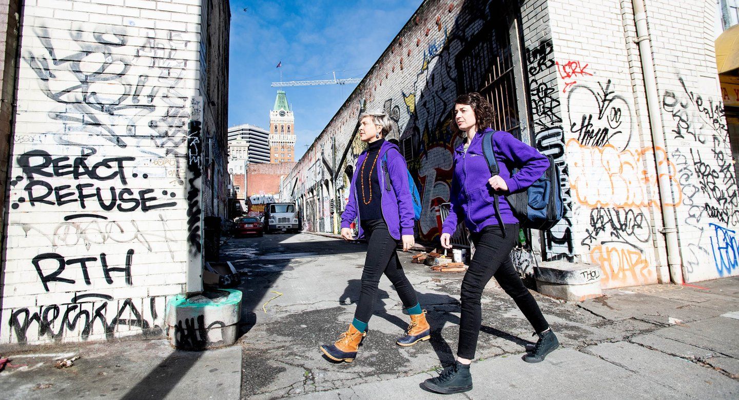 Two public psychiatrists walk by an alley in the streets of Oakland