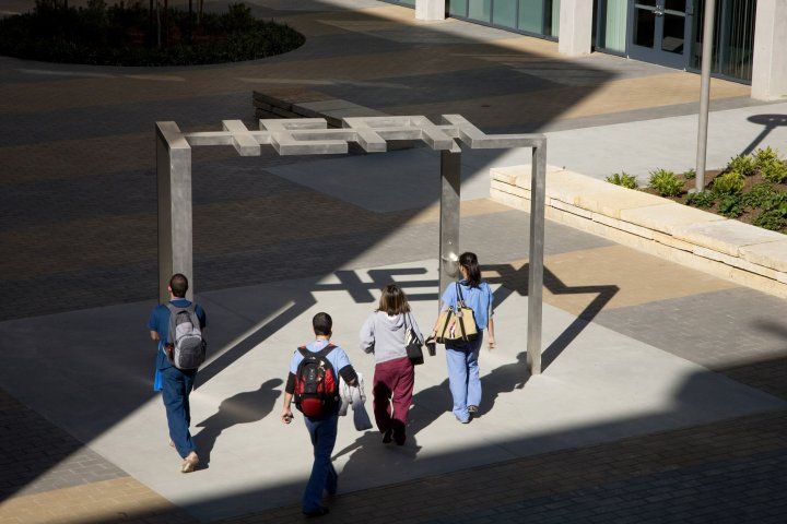 four students walk under a sign that says "heal"