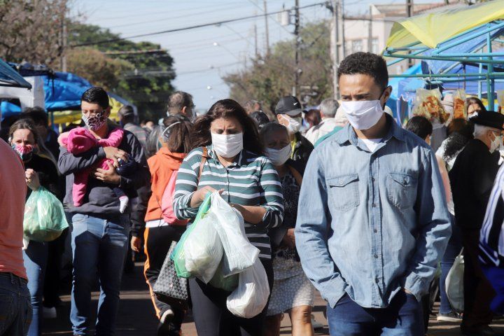 people walk with masks in a market in Brazil