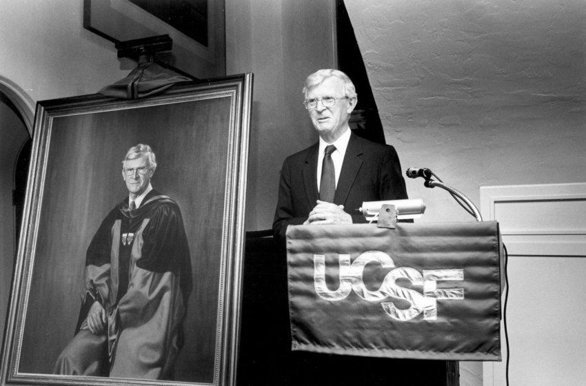 Philip Lee standing at UCSF podium next to his portrait