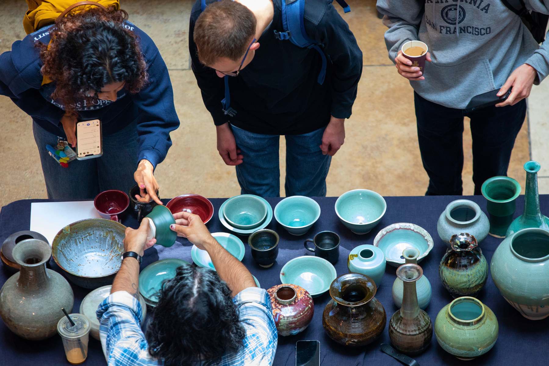 students shop for ceramics made by their classmate