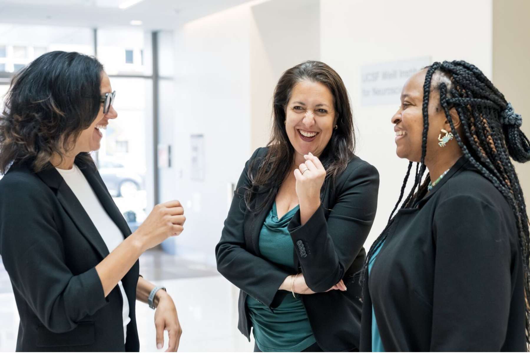 Christina and two others laugh in lobby of building