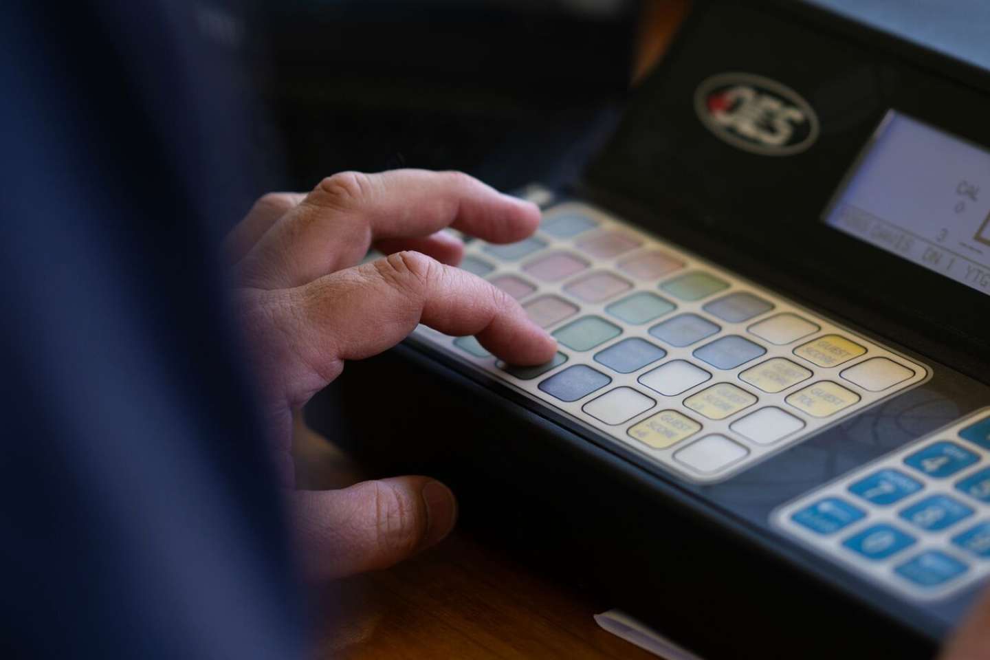 fingers touching various buttons on a master control panel.