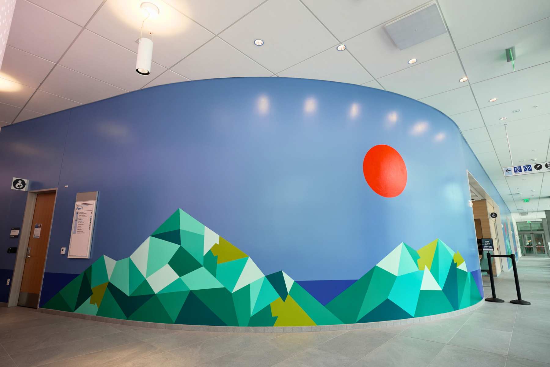 large colorful mural in office wall with strong blues and hues of pastel greens