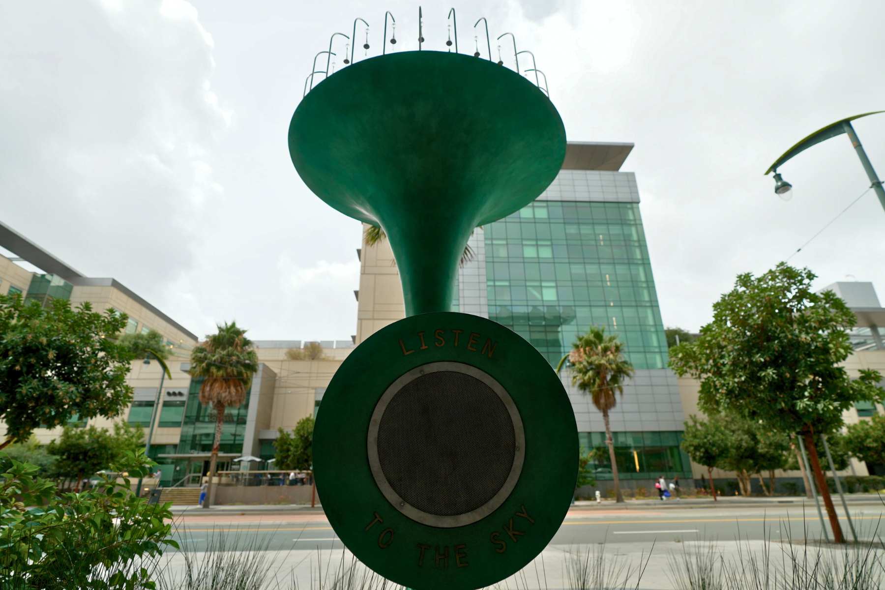 green trumpet sculpture from below throws water