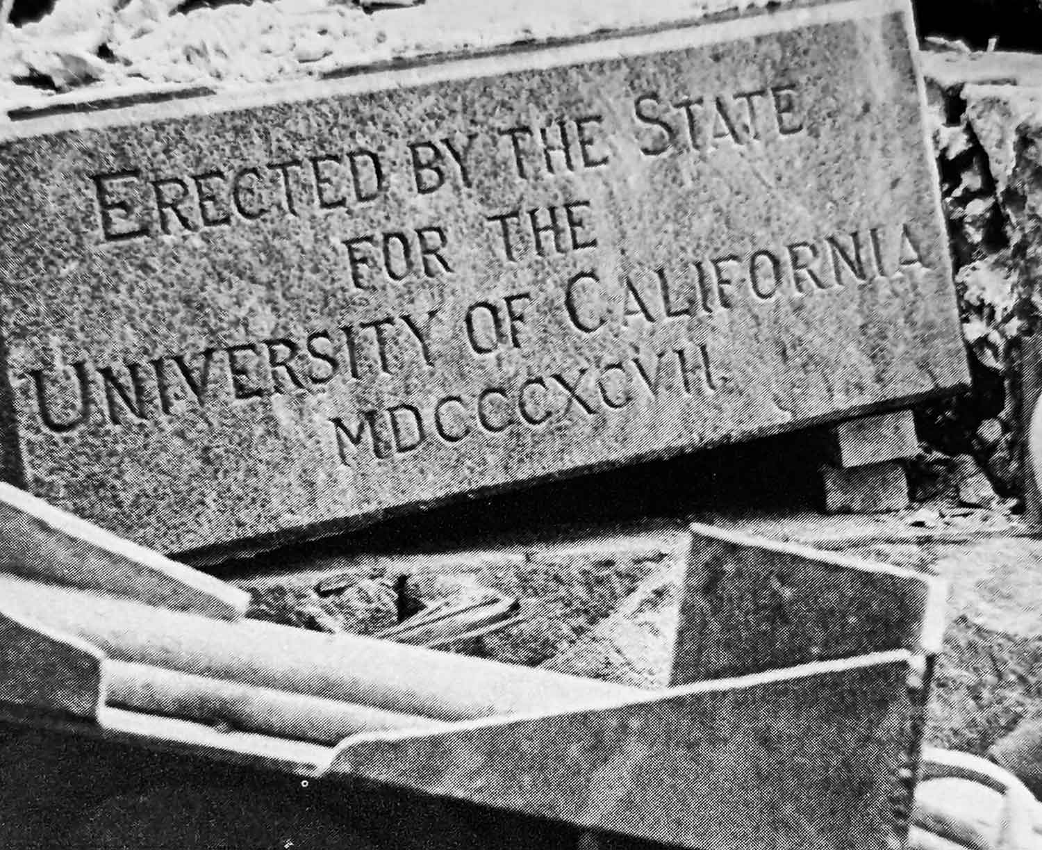 A black and white photograph of the first cornerstone laid that marked the beginning of the Parnassus Heights Campus. It reads "Erected by the State for the University of California," along with the Roman numerals M D C C C X C V I I, which stand for the year 1897.