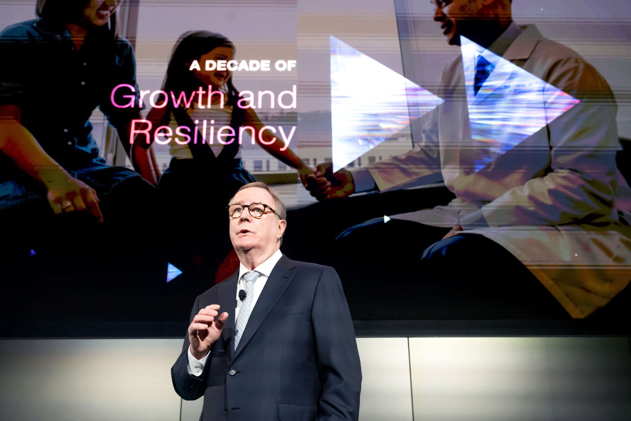 Chancellor stands in front of screen with text "A decade of growth and resiliency."