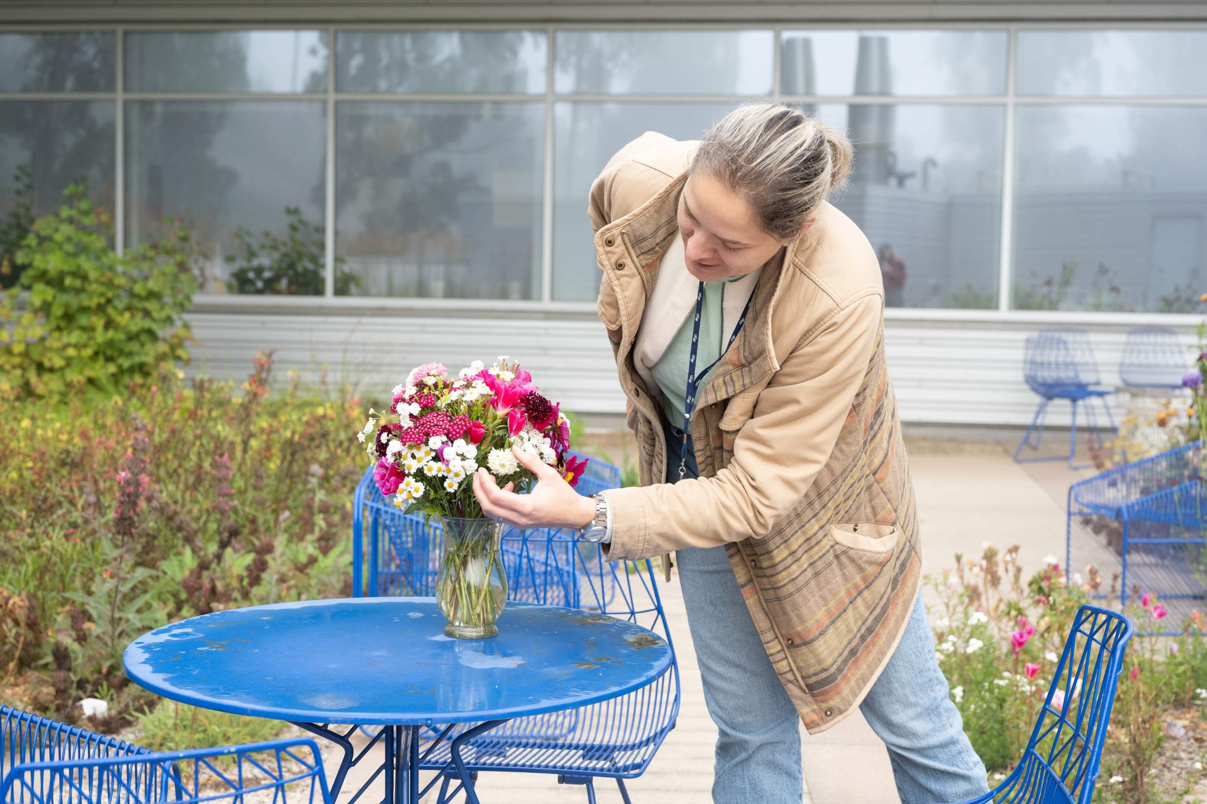 Researcher arranges flowers in vase.