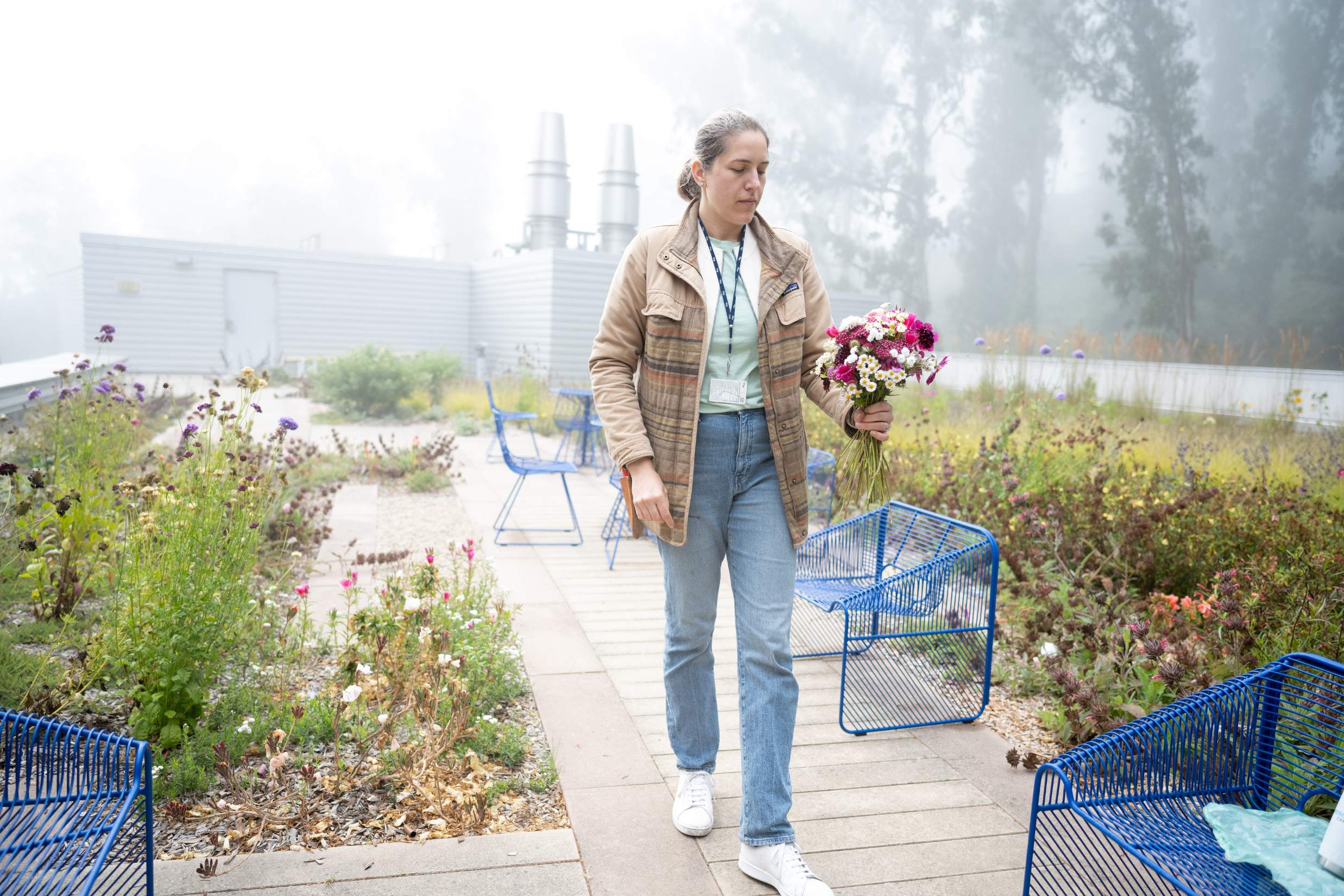 Research walks towards building after picking flowers.