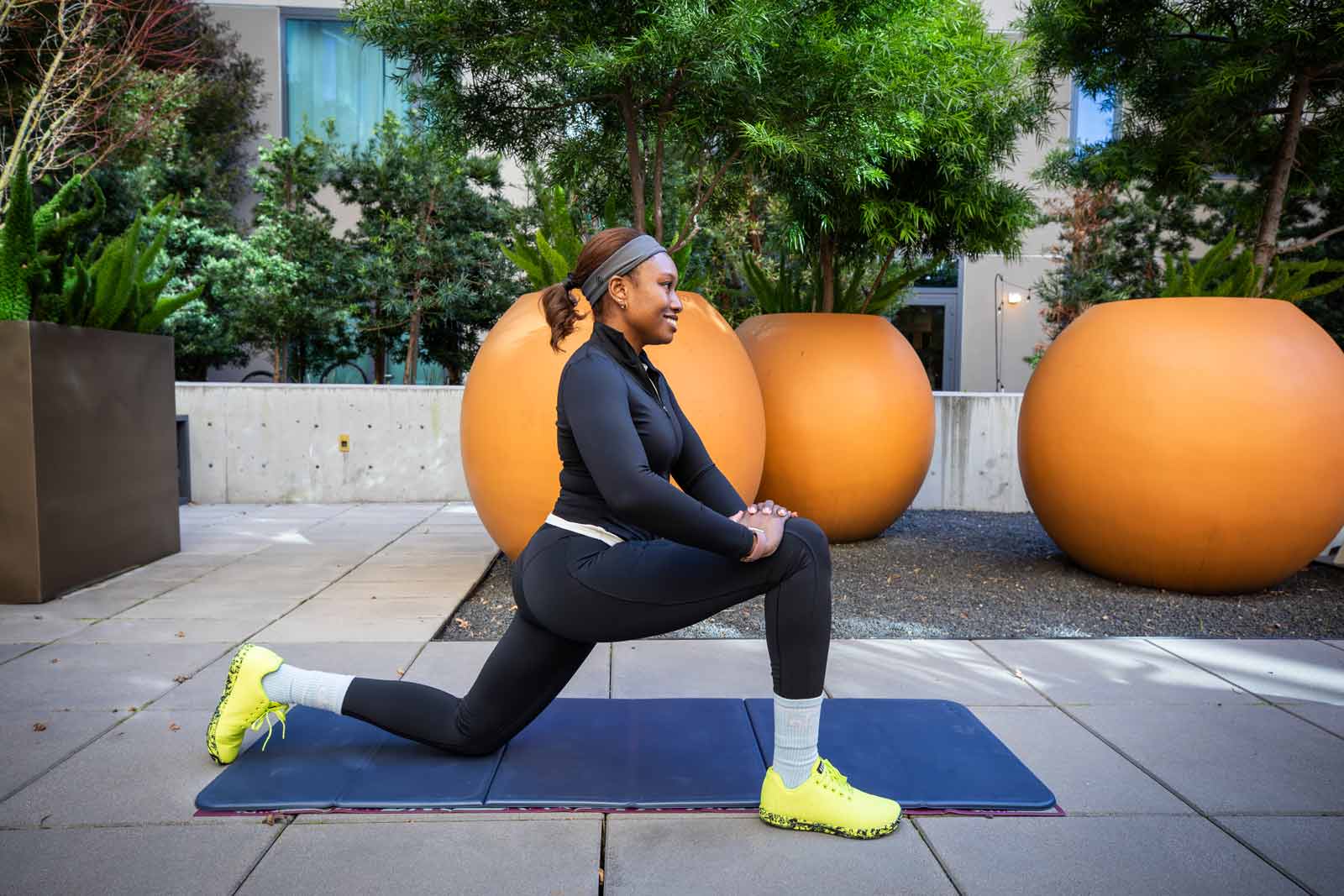 Neurologist Lauren Patrick stretches on a yoga mat outside of her home.