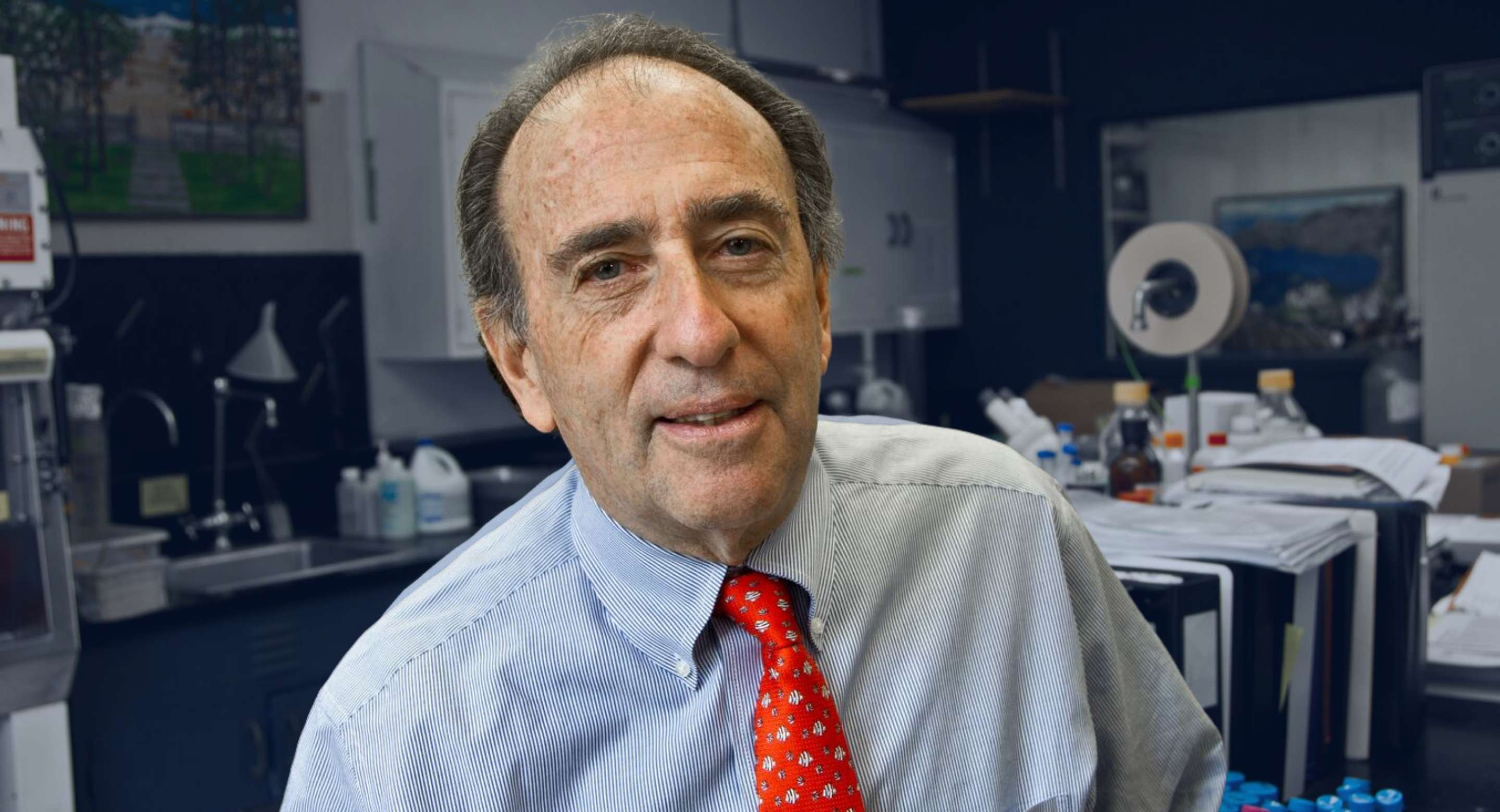 Jay Levy poses in red tie in laboratory.