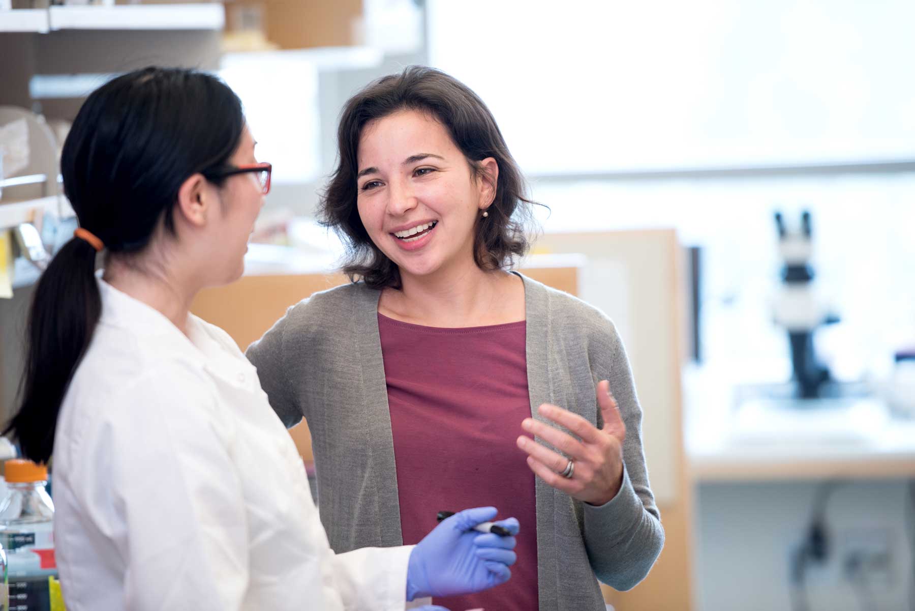 Anna Victoria Molfosky smiles as she speaks with research associate Sarah Wang in her lab at U C S F.