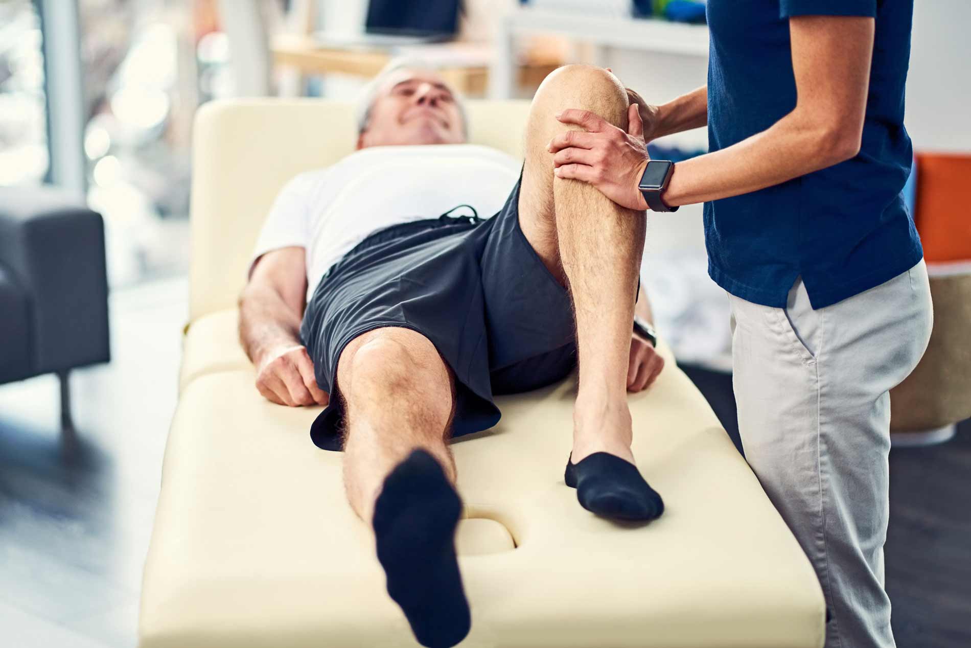 A physical therapist works with an elderly man.