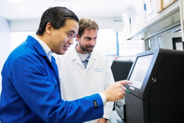 Charles Chiu and a colleague use a DNA sequencer