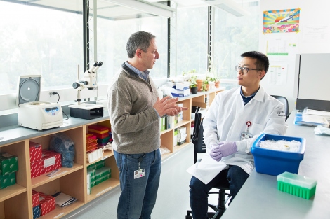 Ophir Klein talks with Nick Wang in a lab