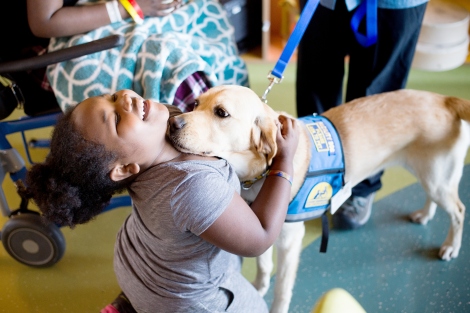 Kimono, a 2-year-old golden retriever/lab spends time with 9-year-old Jamaira Lampkins