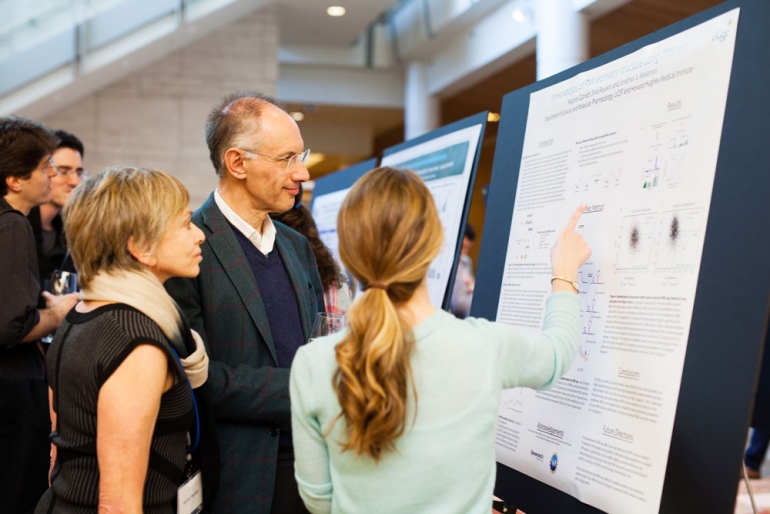 Sir Michael Moritz and Harriet Heyman discuss research with a fourth-year Discovery Fellow Meghan Zubradt (Biomedical Sciences)