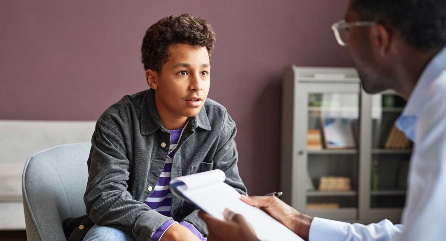 A young pre-adolescent boy speaks with a psychologist.