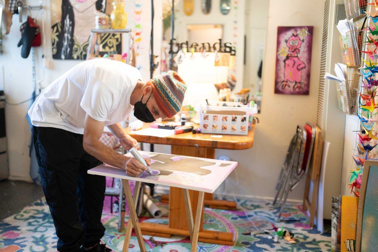 Shawn Connolly paints on a canvas in his workshop.