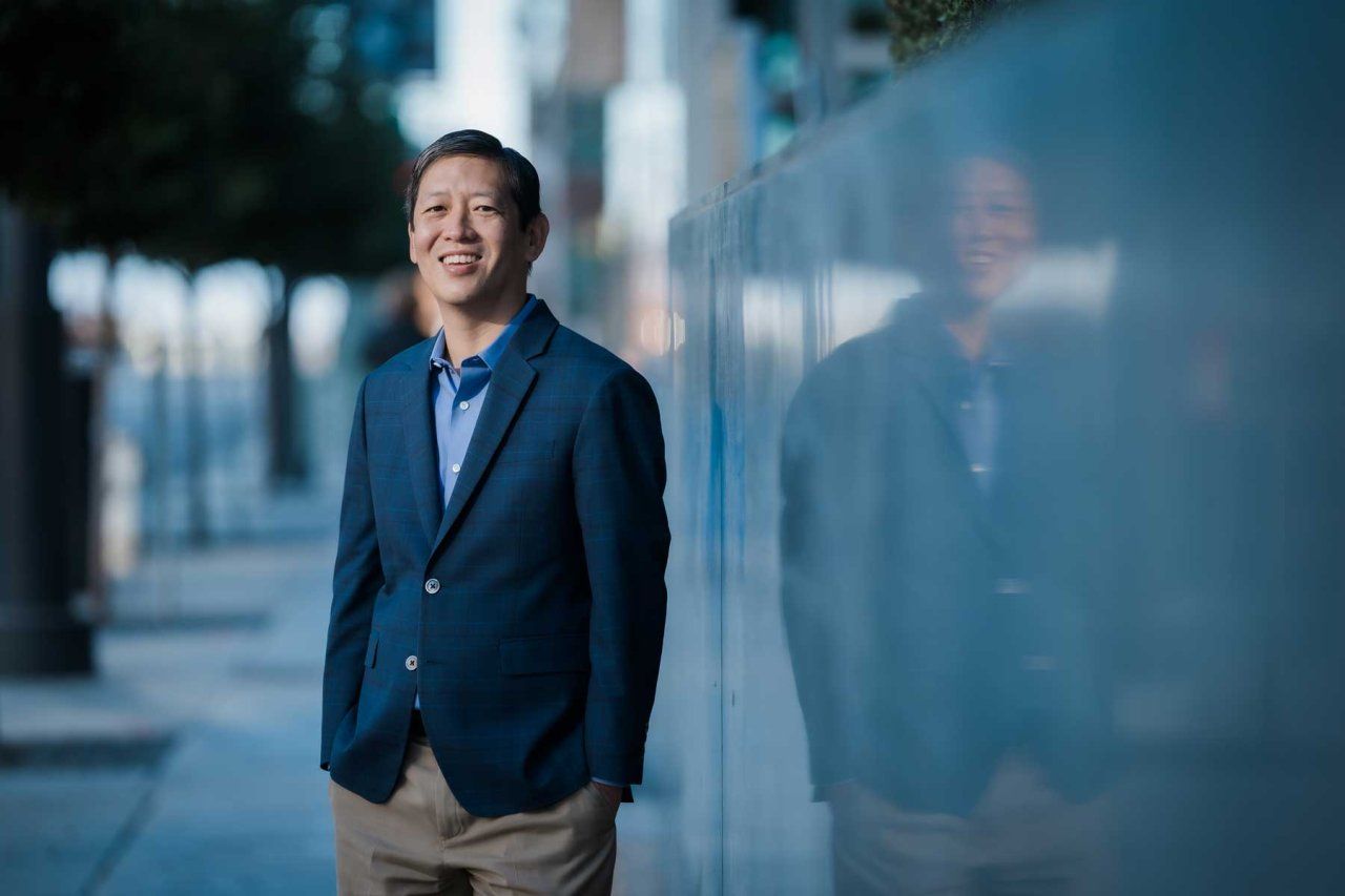 Felix Feng poses for a portrait outdoors among a concrete backdrop.