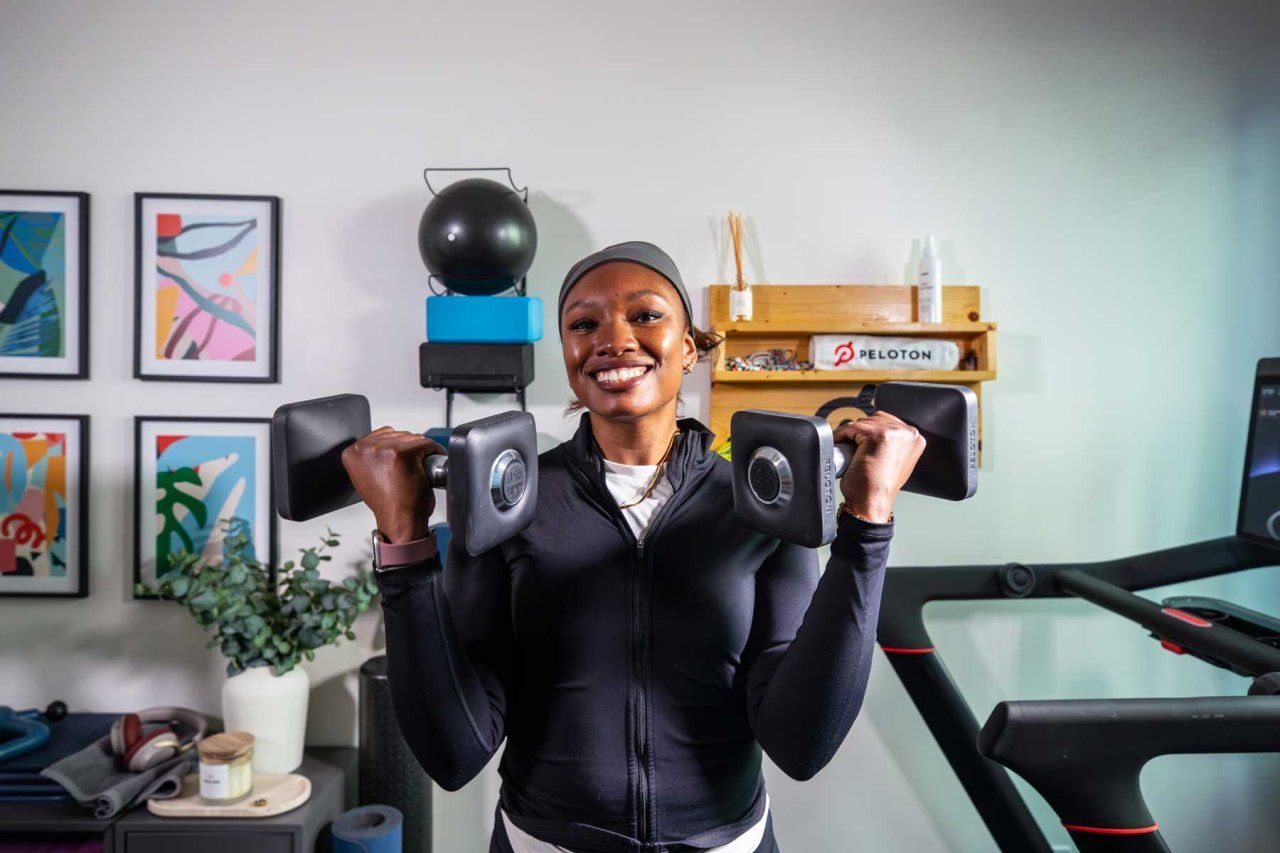 Neurologist Lauren Patrick smiles as she lifts weight at her home gym.