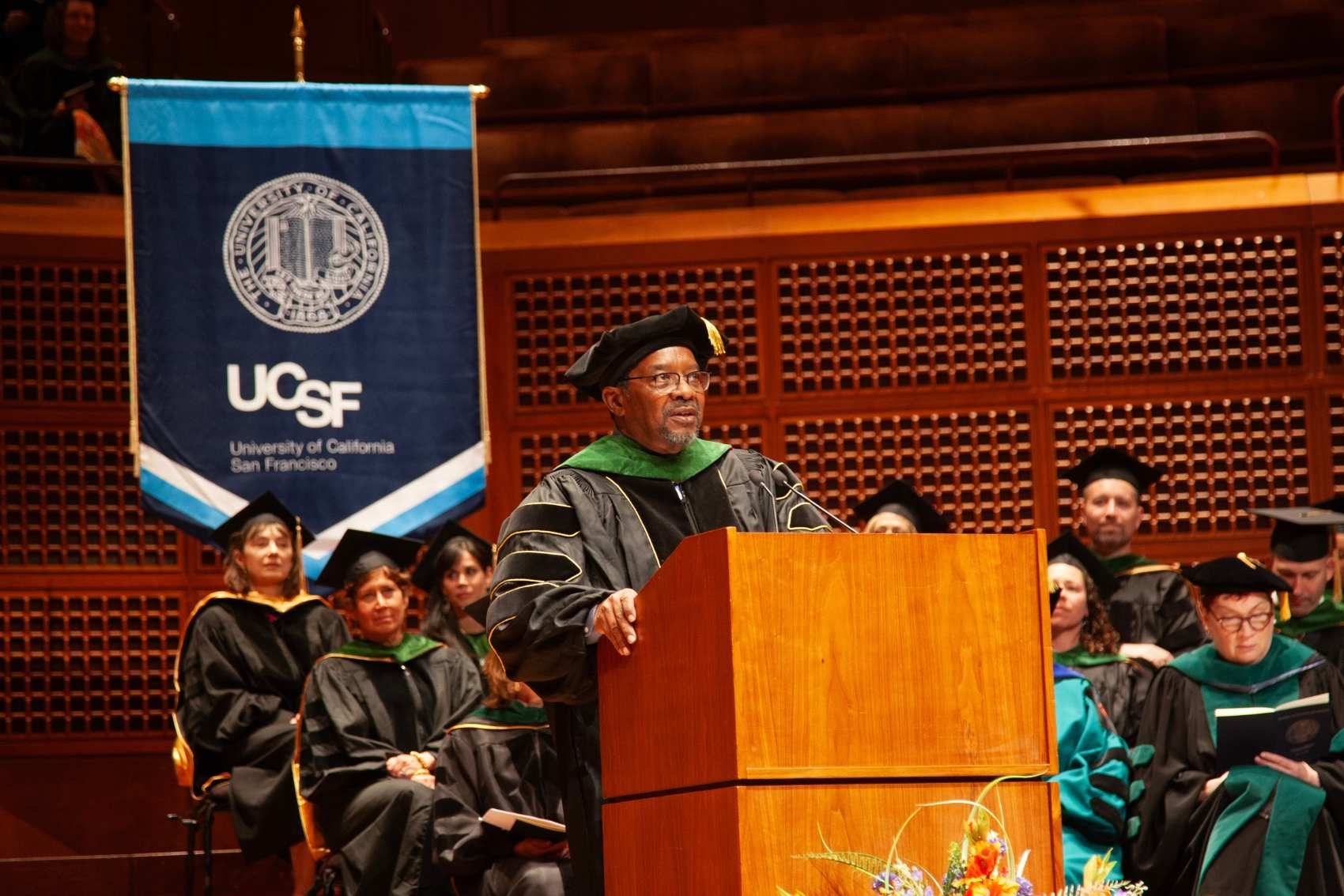 Dean Talmadge E. King, Jr speaks at podium in front of large audience