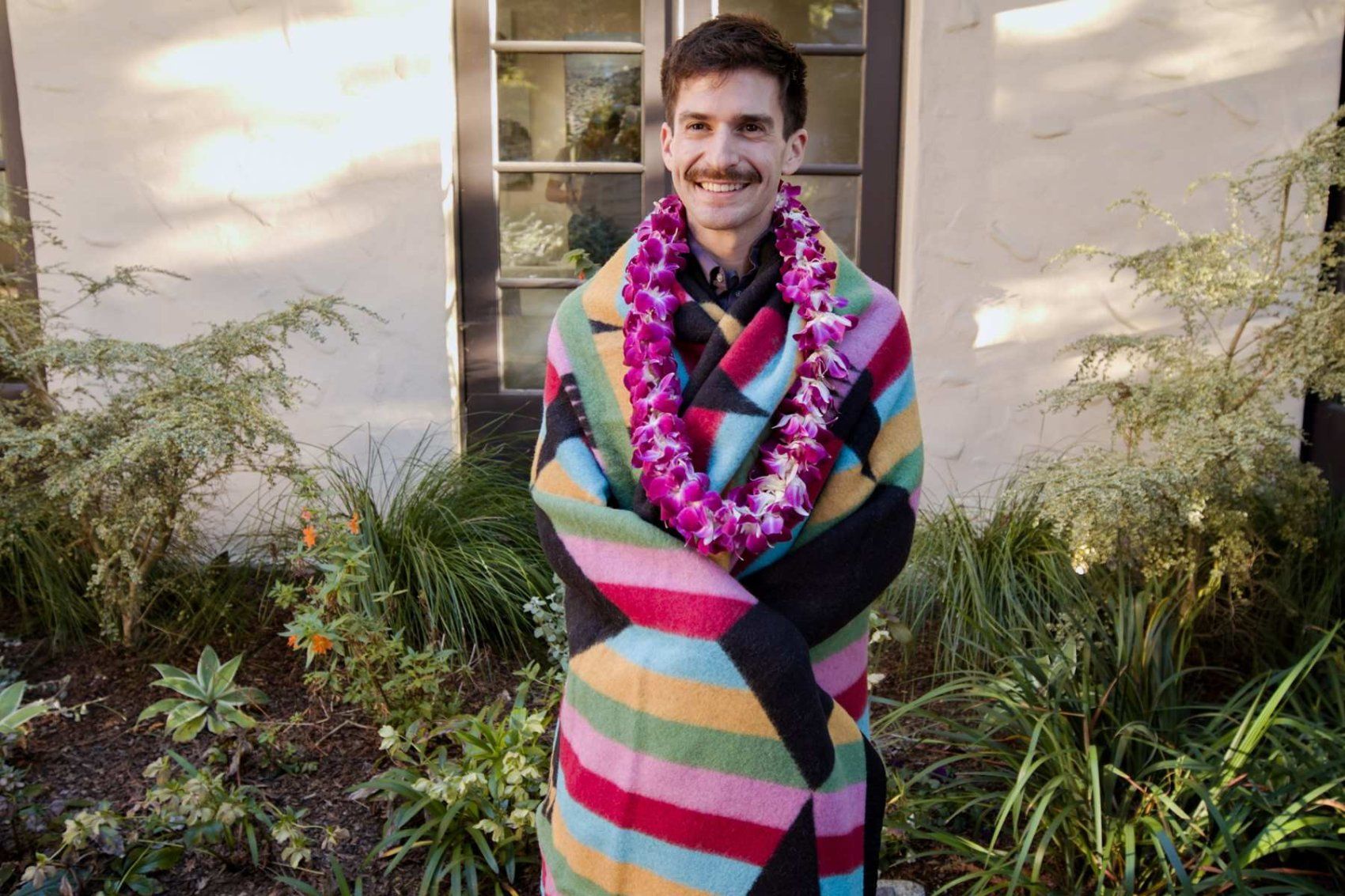Kyle Lakatos holds blanket in garden after graduation