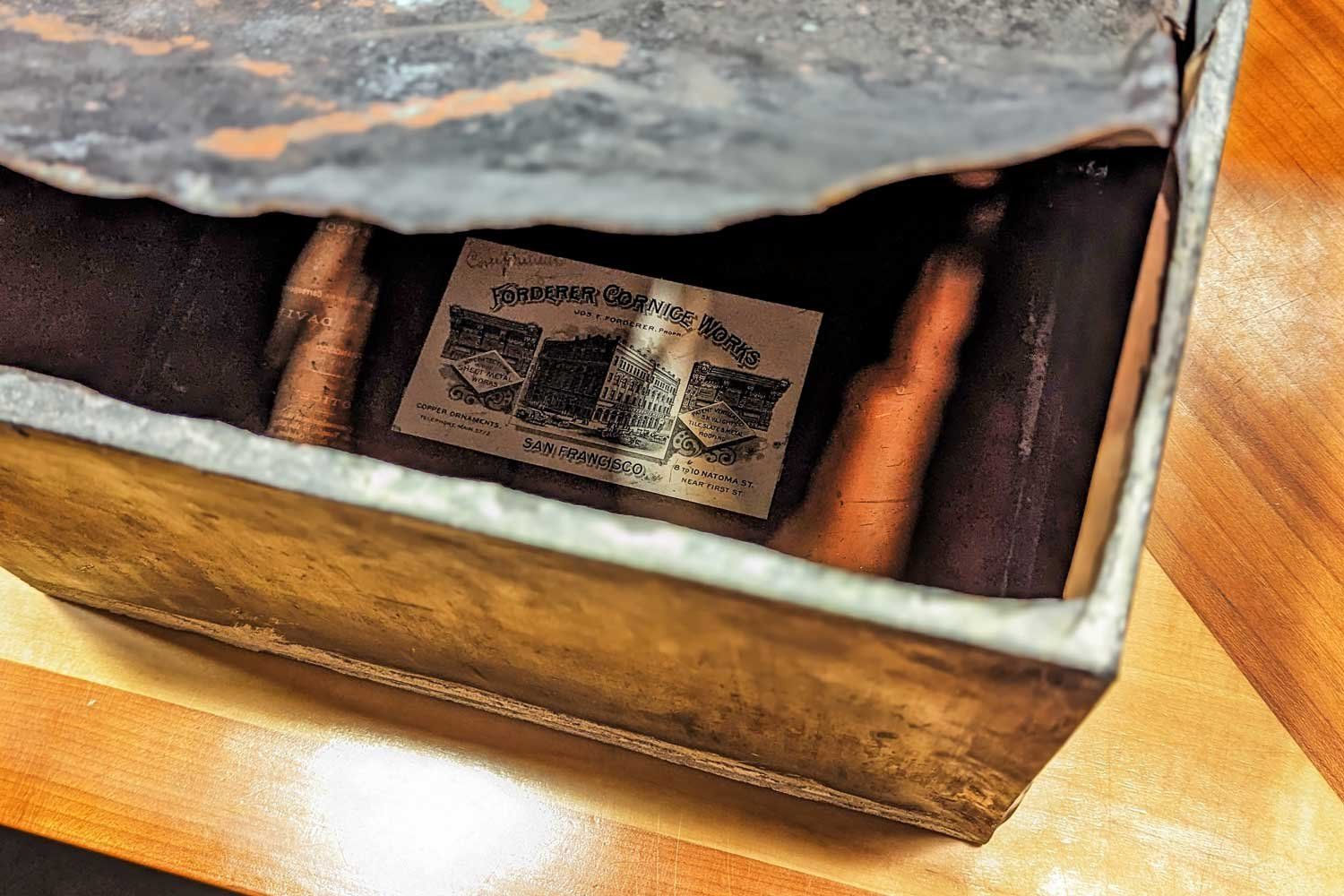 A copper box time capsule that was at the cornerstone of the first building at Parnassus Heights. Inside is a tag with the name of its manufacturer, Forderer Cornice Works.