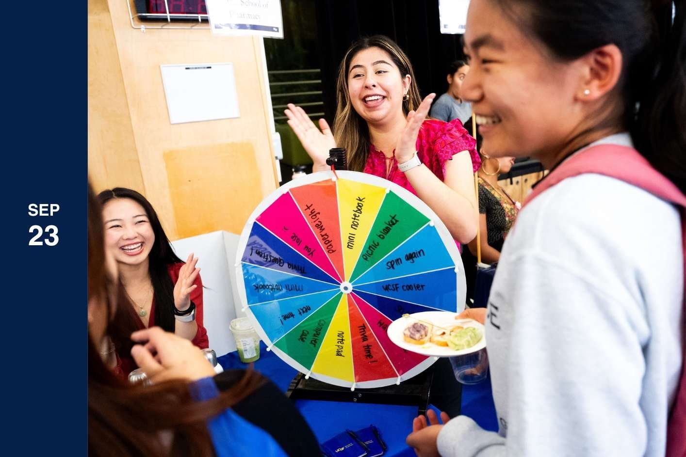 woman spins wheel smiling.