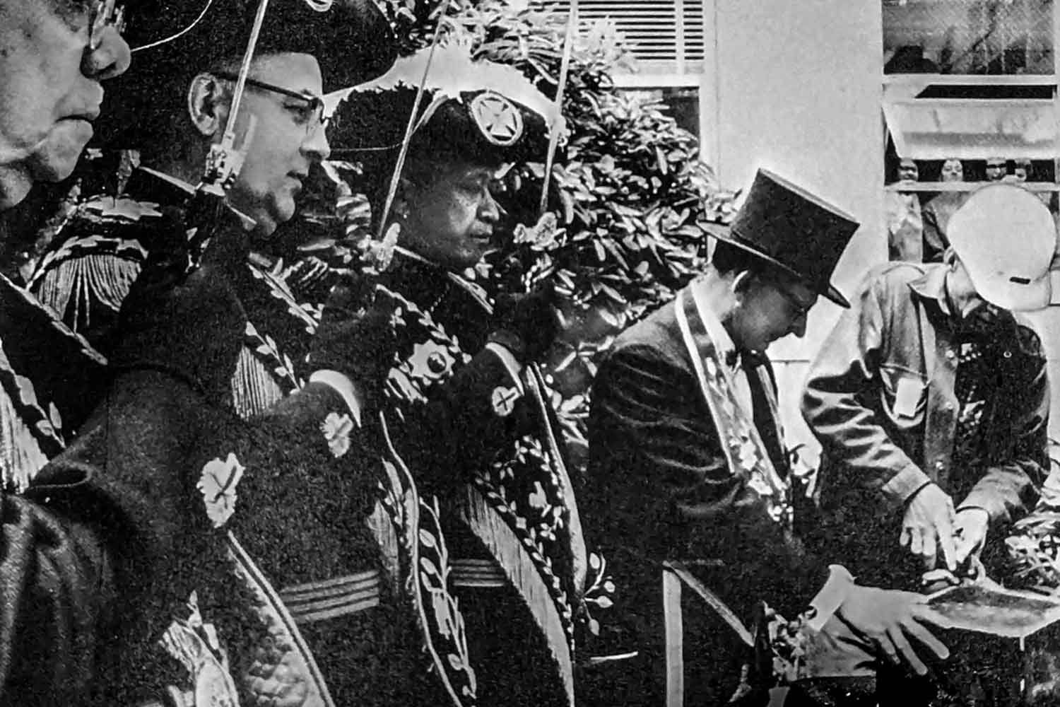 A black and white photo from 1967 of men in regalia openeing the time capsule that was left in the cornerstone of the first ever building at the Parnassus Heights campus.