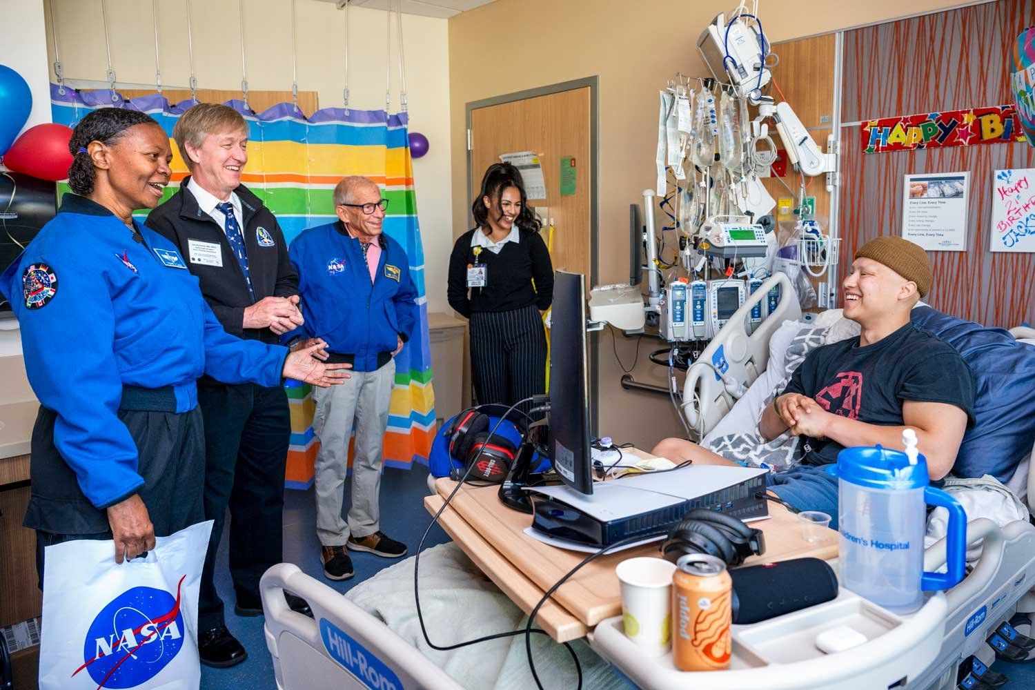 Three NASA astornauts visit a 21-year-old male patient at the oncology ward at U C S F Benioff Children's Hospital San Francisco.