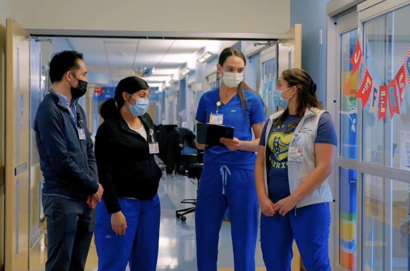 Nurses connect about patients in hallway.