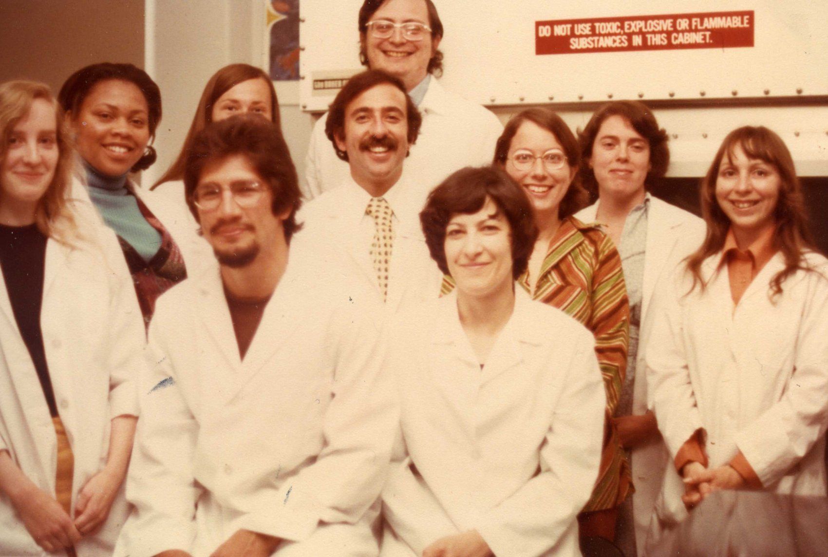 A group of scientist in lab coats pose.