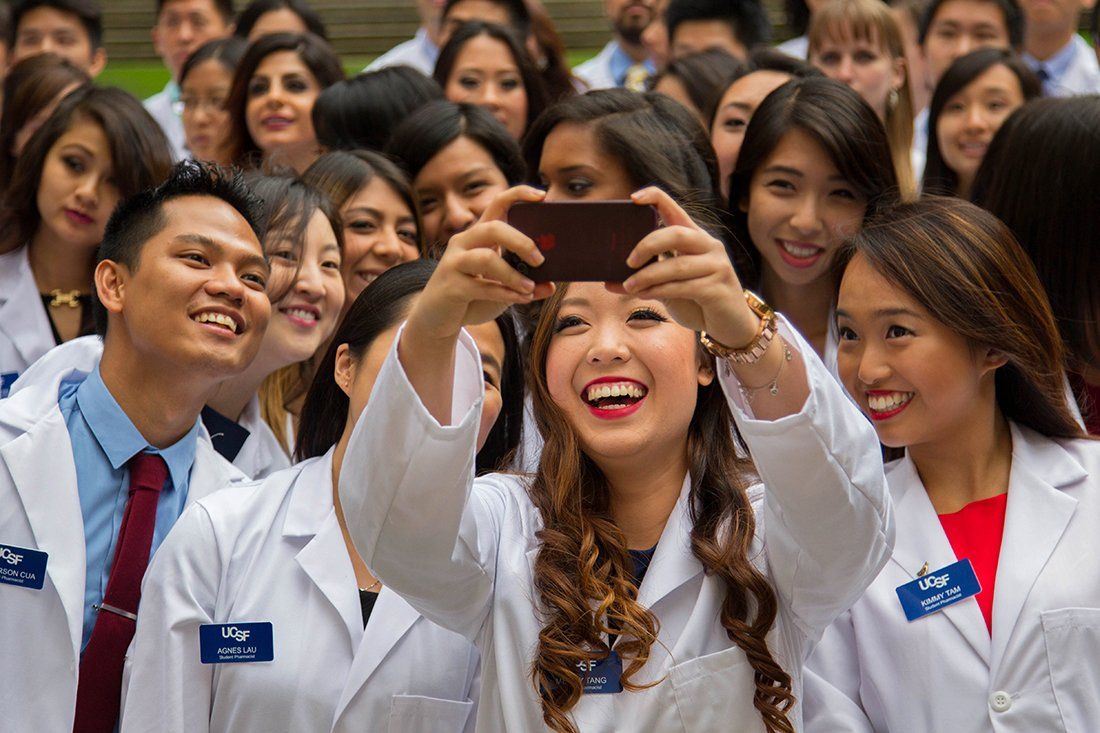 Mercy Tang takes a crowd selfie with her fellow students at the School of Pharmacy white coat ceremony