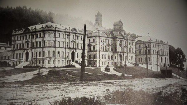 An old, sepia photo of the first building at Parnassus Heights, showing the natural sand dunes in the surrounding area.