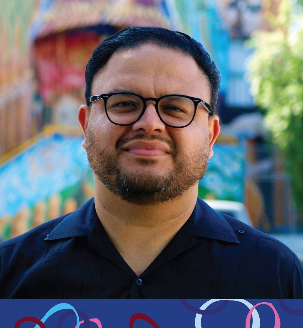 Manuel Tapia looks ahead against the backdrop of a colorful blue building in the Mission.