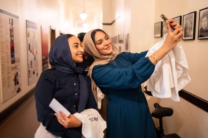 two students take selfie in hallway